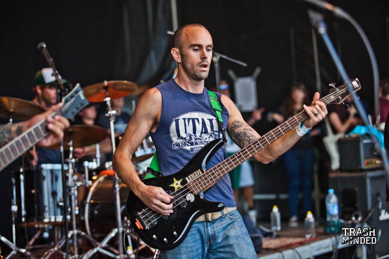 man on stage with multiple guitars and sound equipment