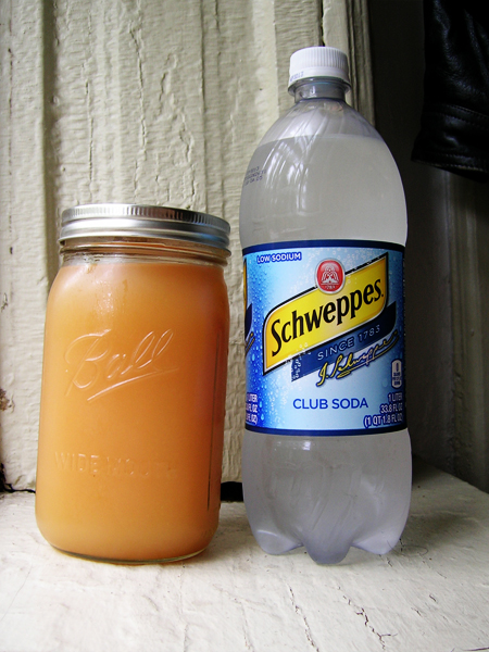 a bottle of schweppes with the liquid beside it