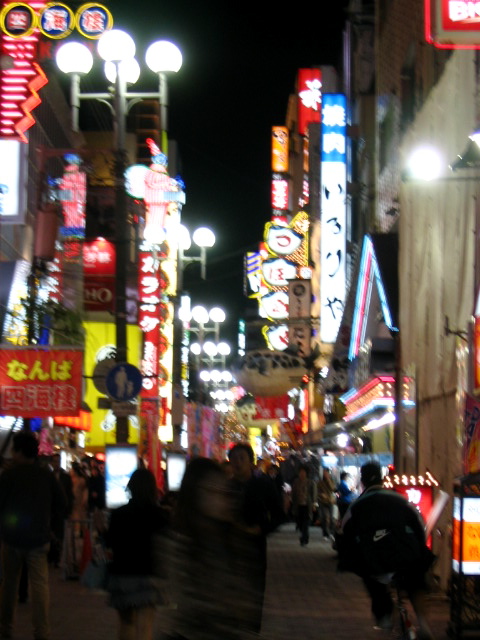 an asian city street has many neon lights and signs