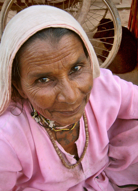 an older woman wearing pink clothing looking straight at the camera
