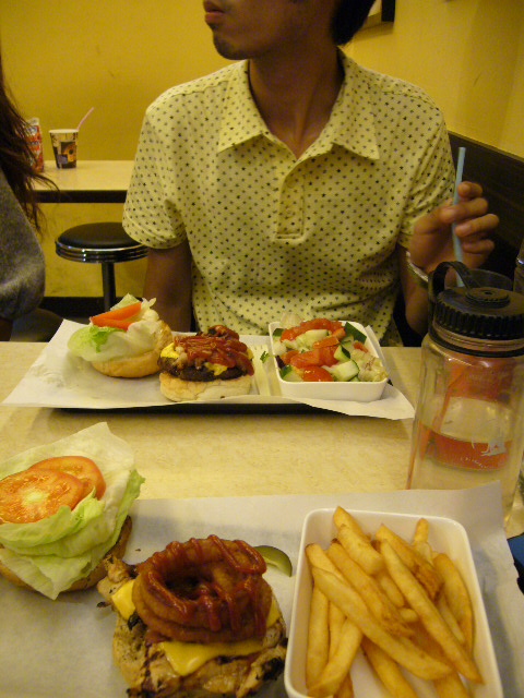 a man and a woman eating hamburgers and fries