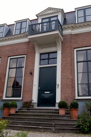 the front entrance of a brick home with a black door