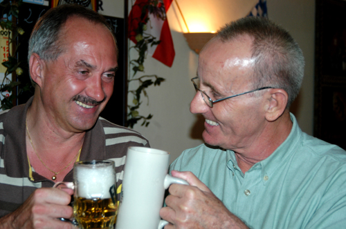 two men are having fun holding a glass