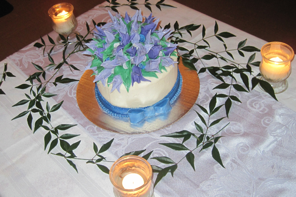 there is a small cake decorated with purple flowers