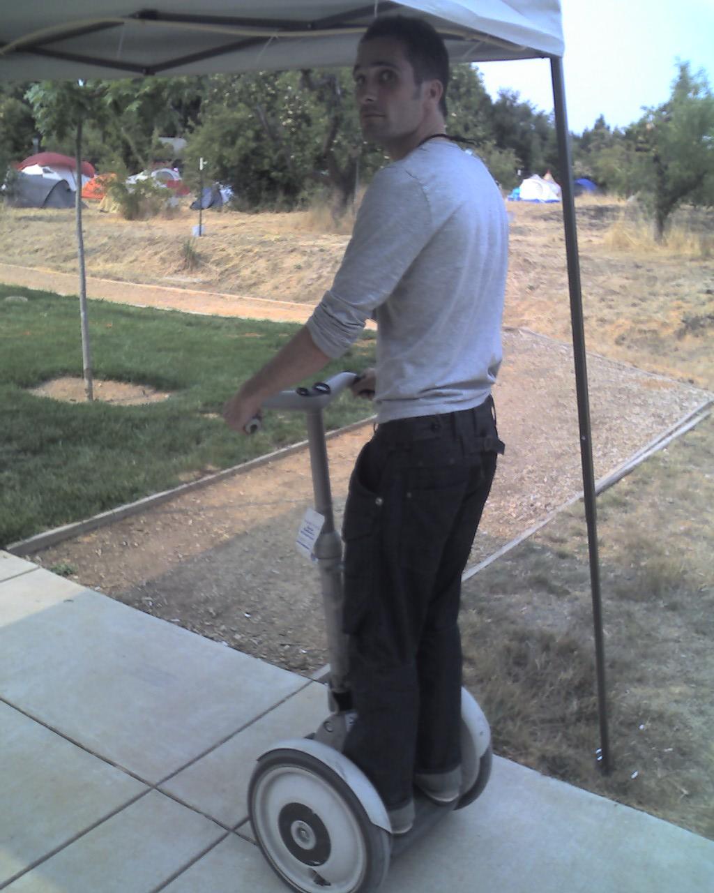 a man riding on top of a segway under a tarp