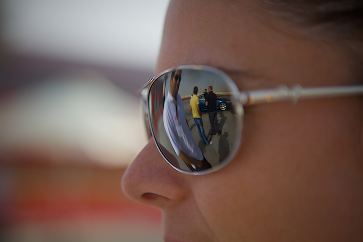 a person with two surf boards reflected in sunglasses