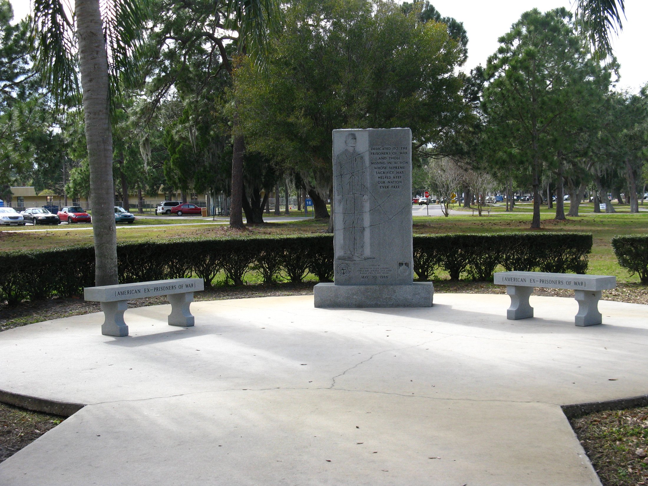 two benches next to a sculpture of a person