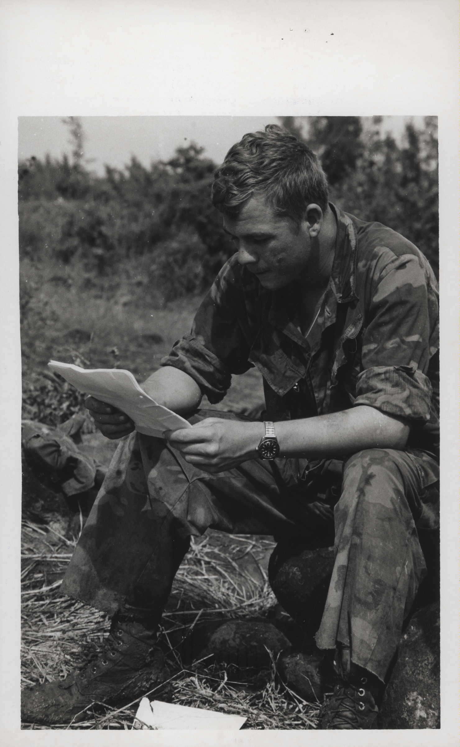 a man reading while sitting in a field