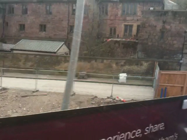 a window view of buildings, construction and a fence