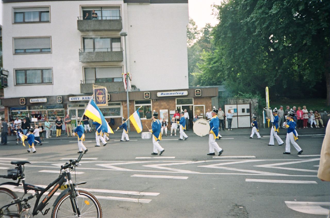 a parade with people and colorful flags in the middle