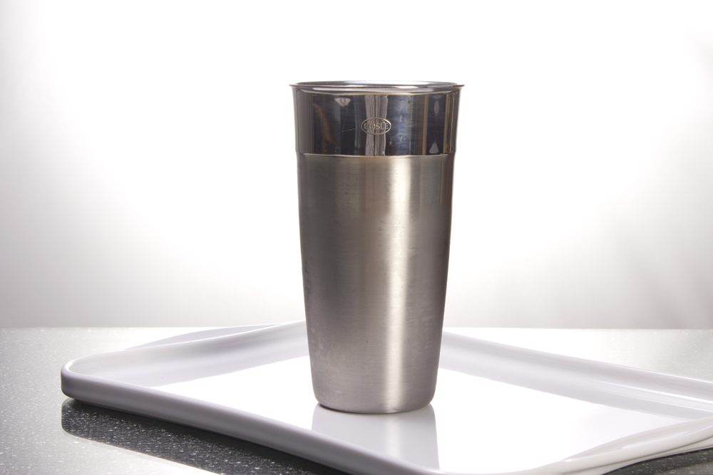the metal cup is sitting on the tray
