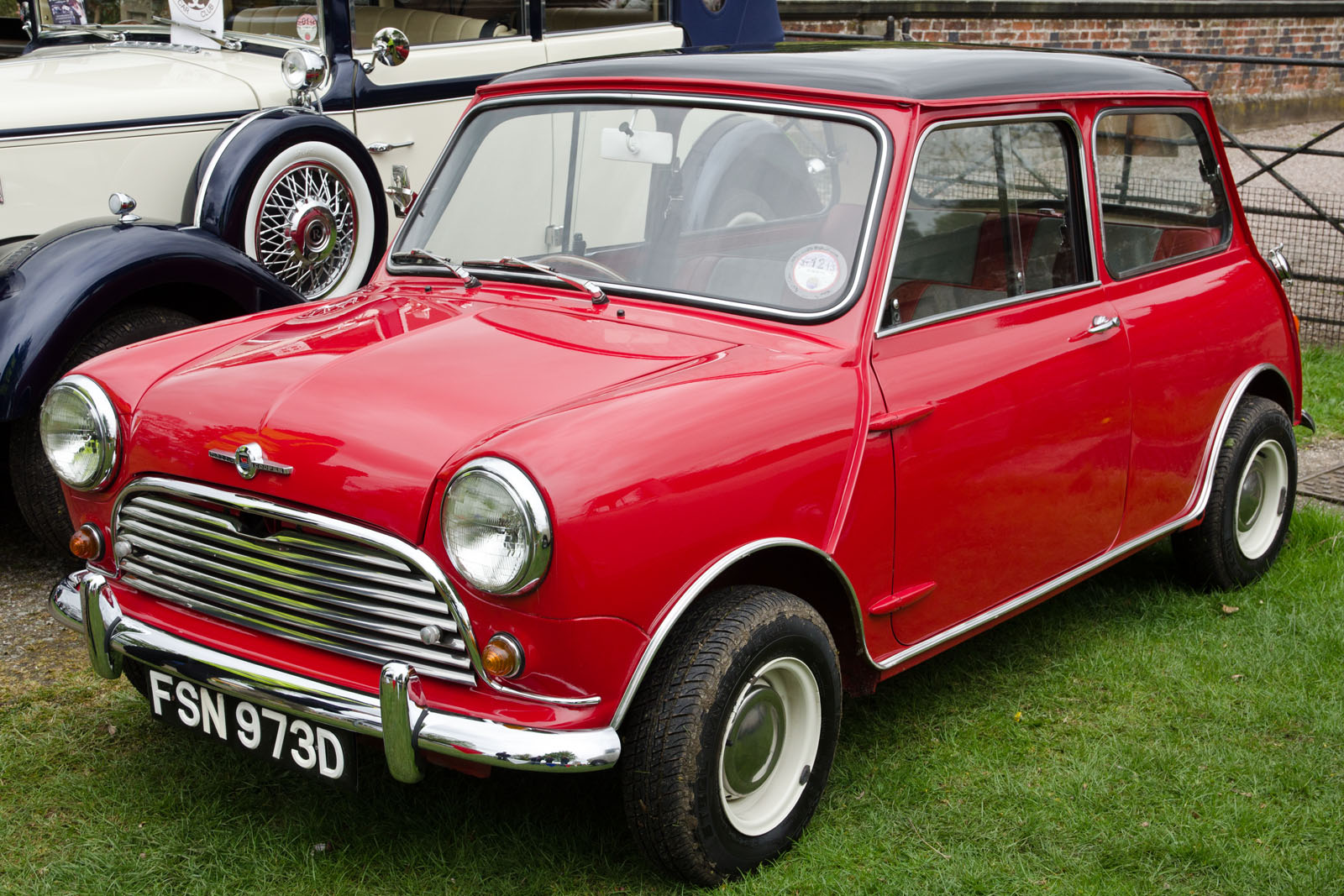 a group of classic cars that are parked on some grass