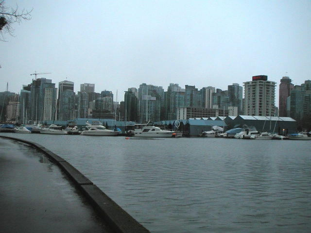 a city skyline with boats and parked cars