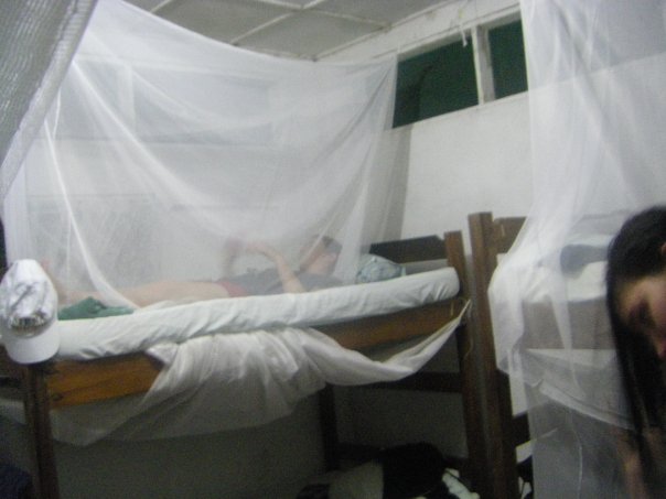 two woman in white curtains on a small bed