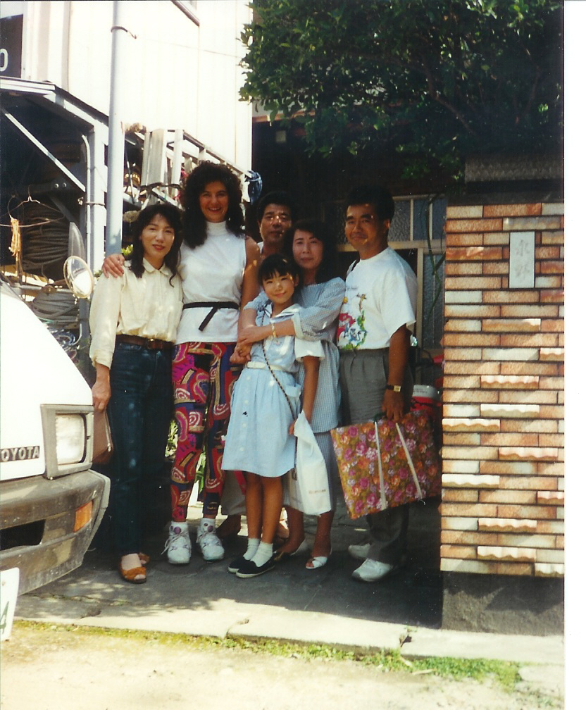 a group of people posing together in front of a house