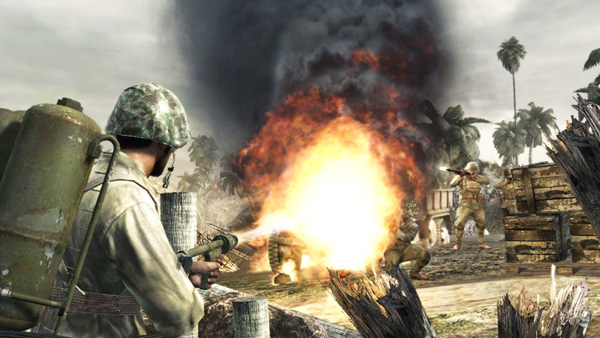 soldiers with guns near a burning tank in a war re - enact game