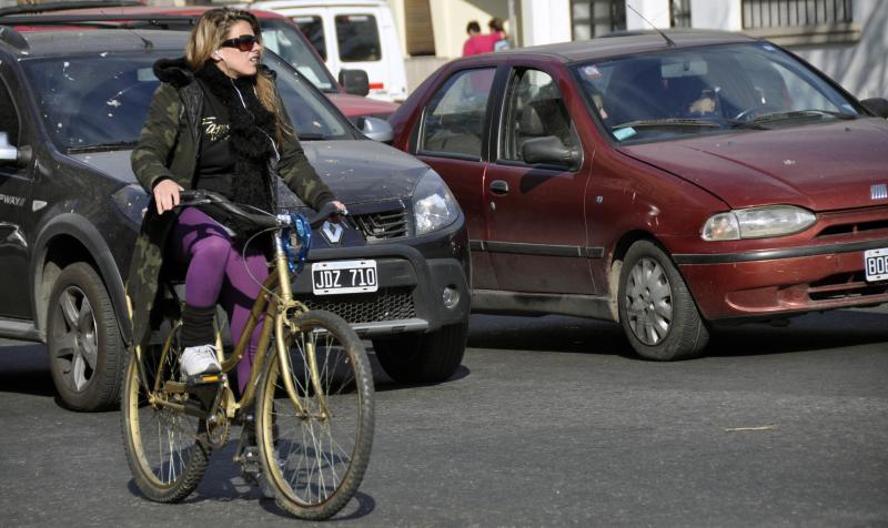 a woman with sunglasses riding a bike across a parking lot