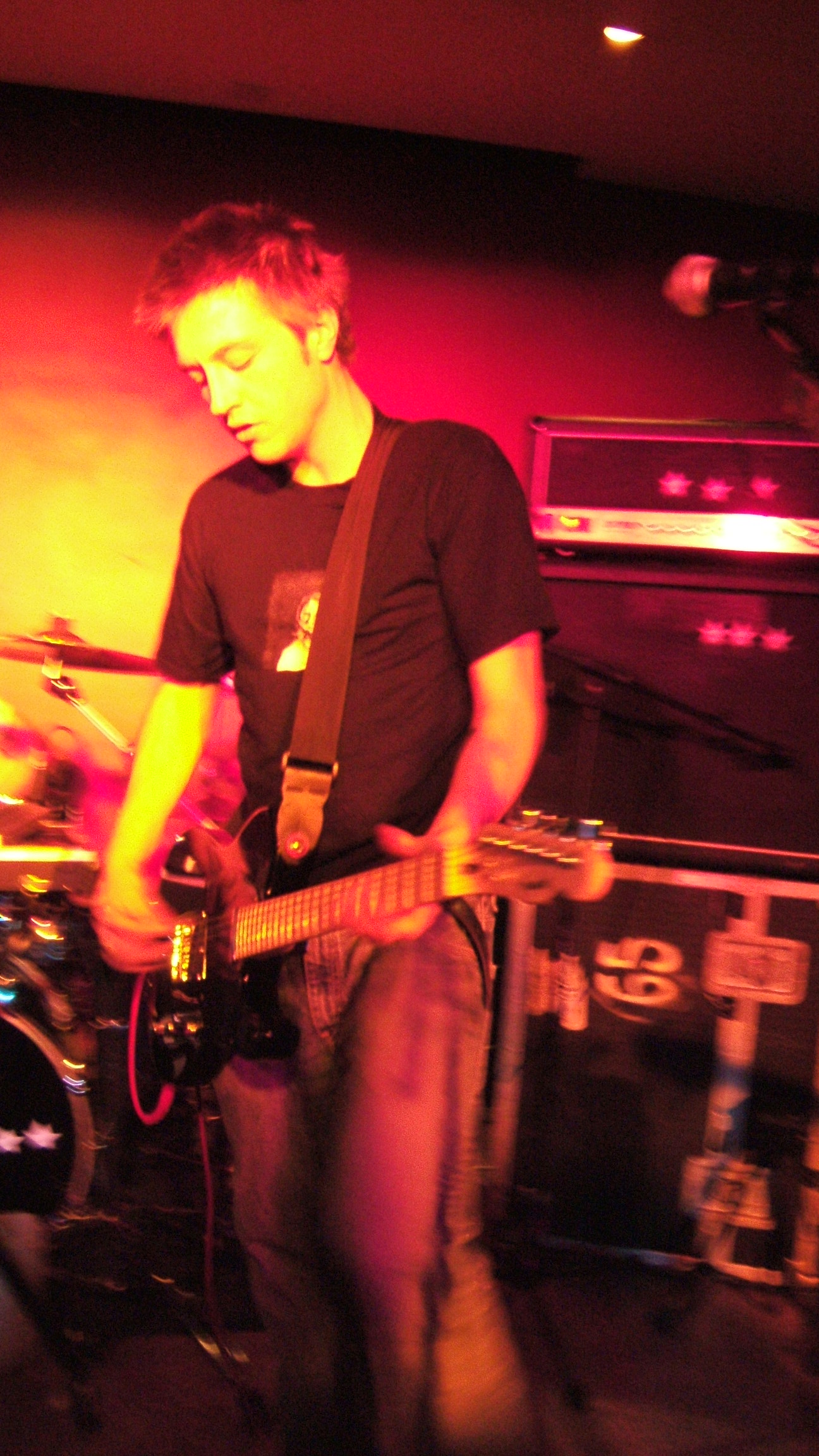 a young man playing guitar in a small room