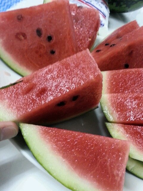 slices of watermelon sit on a white plate