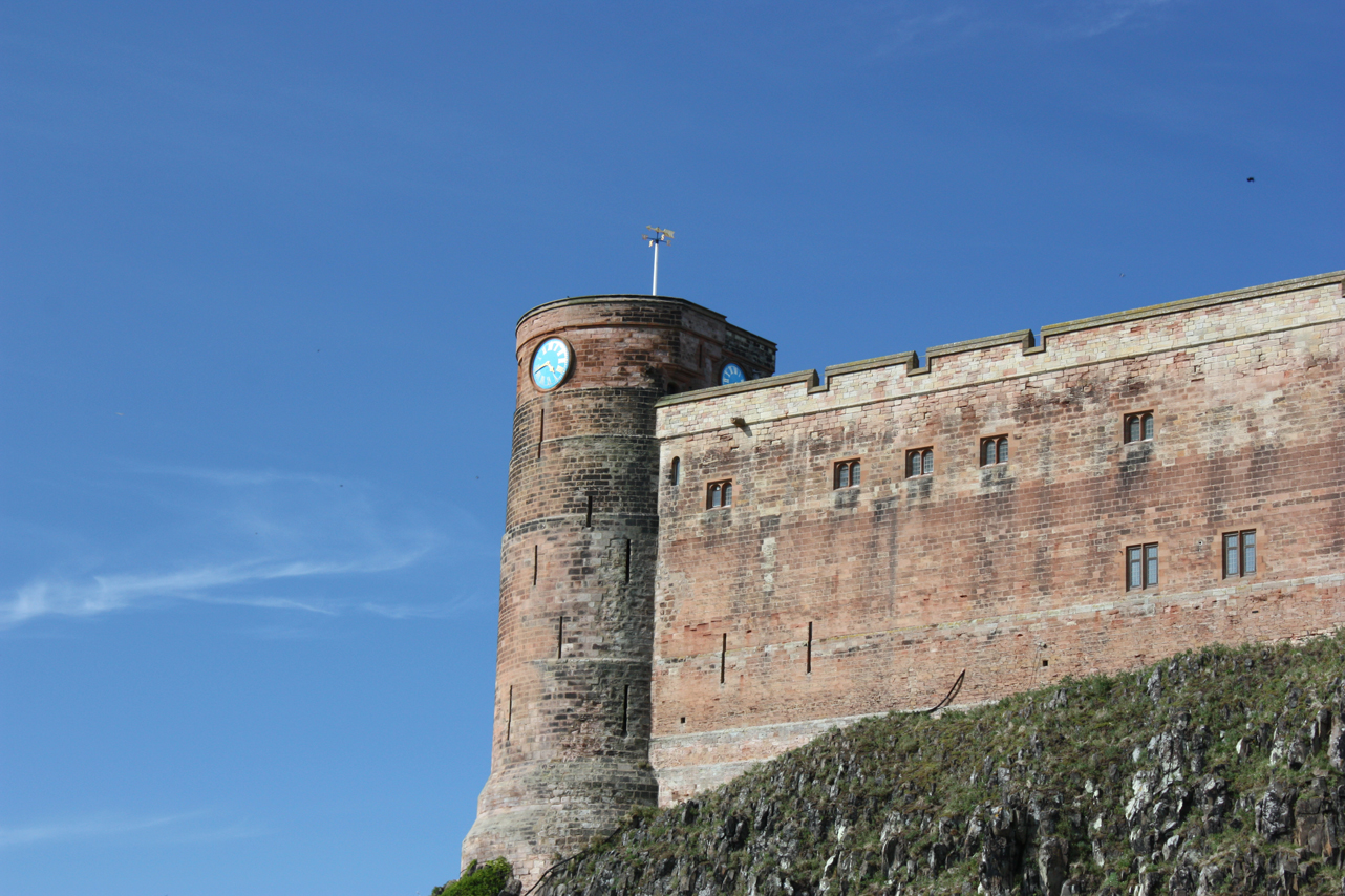 there is a large brick tower and clock on top of a hill