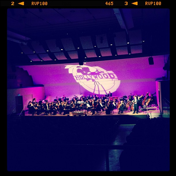 the orchestra has performed on stage and purple lit background