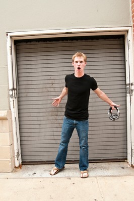 a boy is standing outside with his arms out in front of a garage door