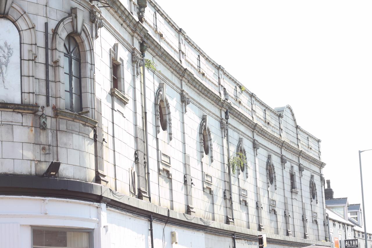 an old white brick building with arched window frames