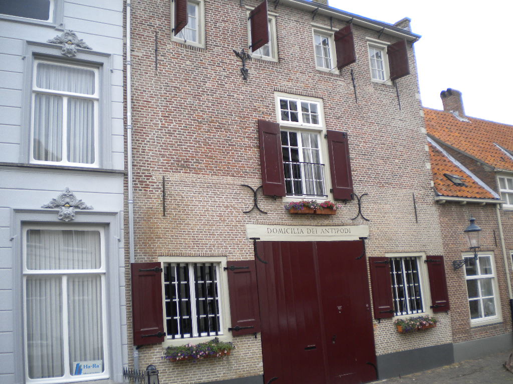 a brick building with closed shutters is on a street corner