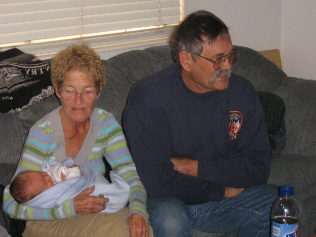 an older man and a woman hold their newborn child