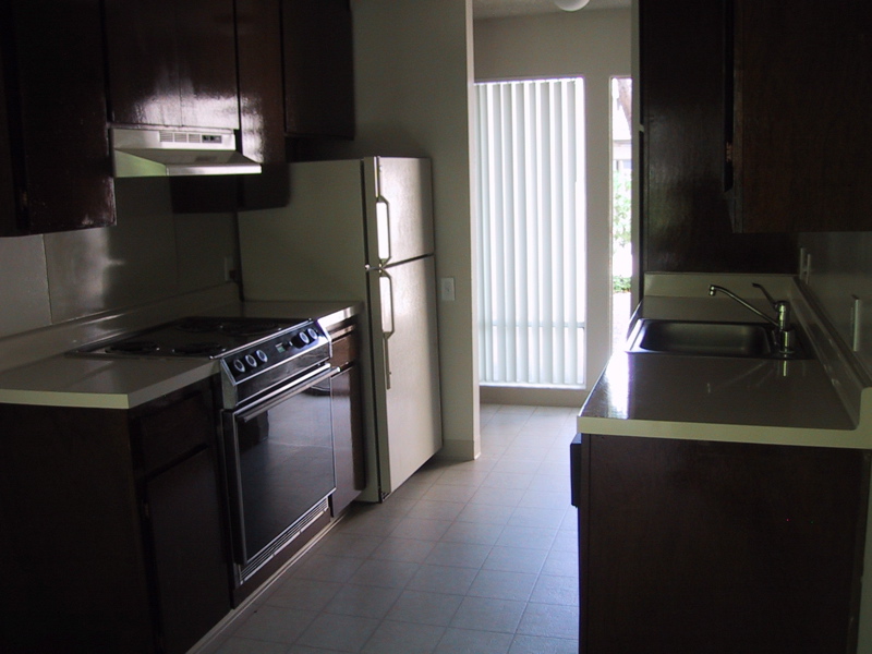 a small apartment kitchen with refrigerator, oven and microwave