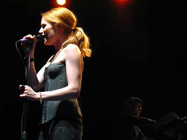 a woman singing in front of a microphone