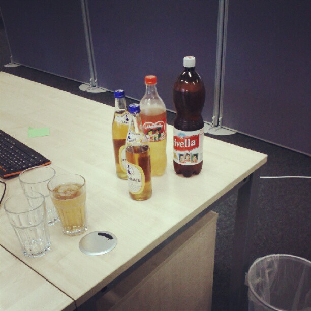 bottles of liquor sitting on a desk with a computer next to it