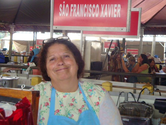 a woman in an apron standing under a sign