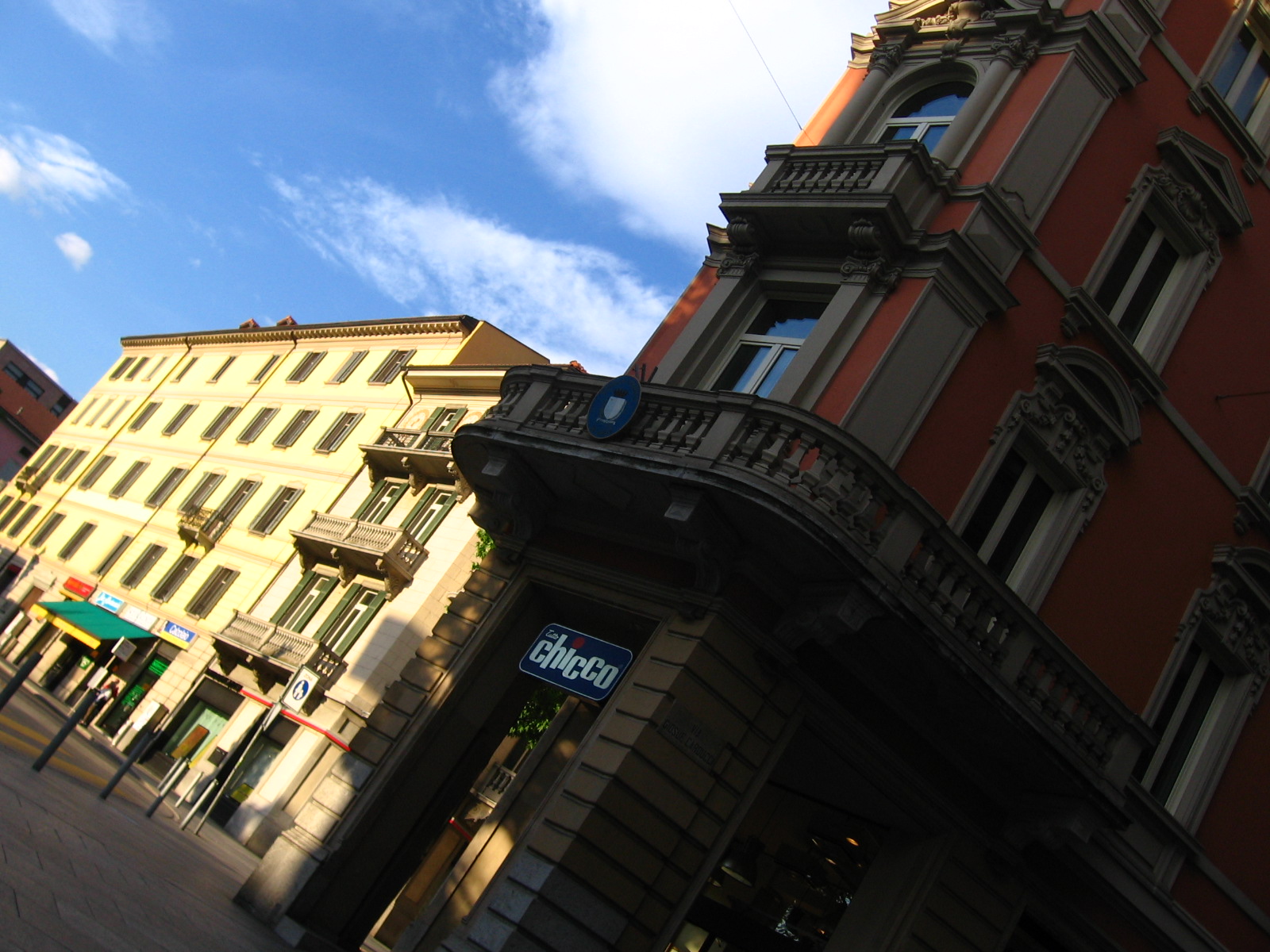 buildings line a street and a blue sign is on the front