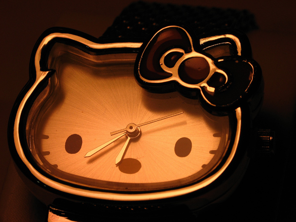 a hello kitty clock lit up in the dark