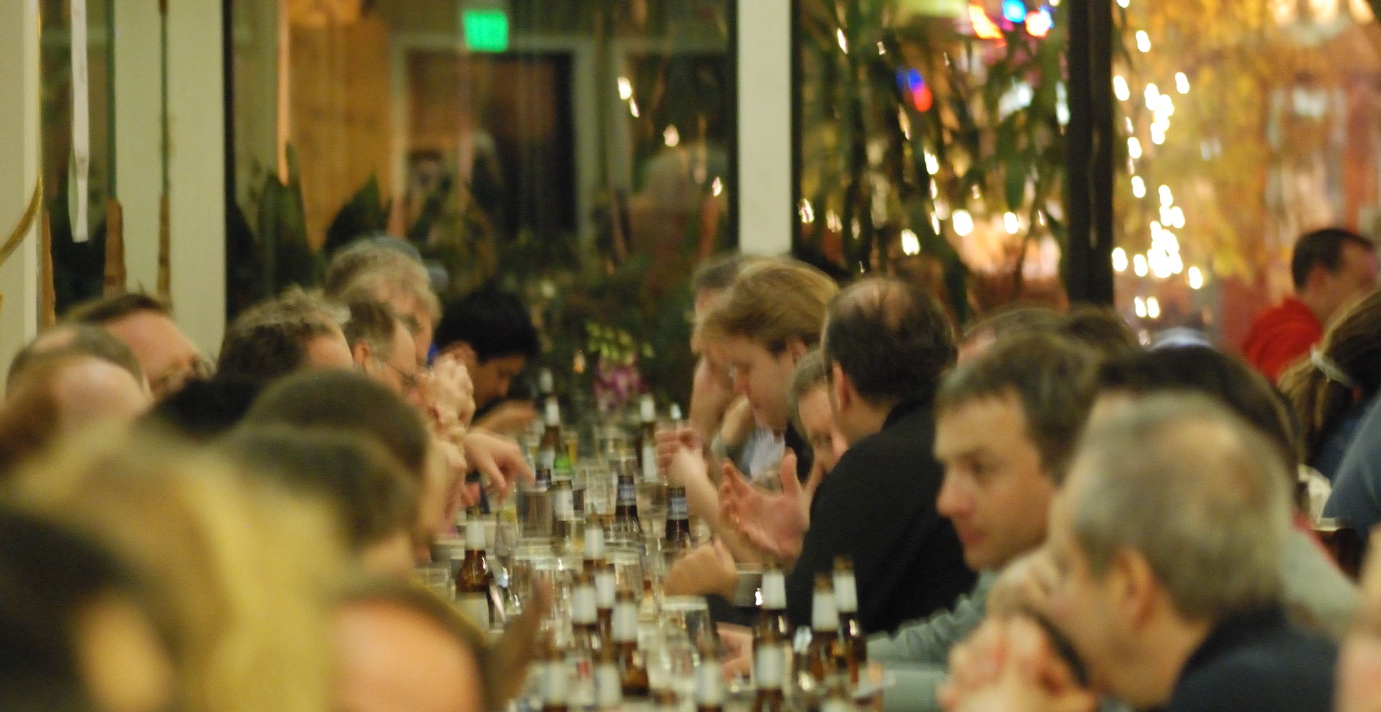 large crowd at a table with lots of people sitting at them