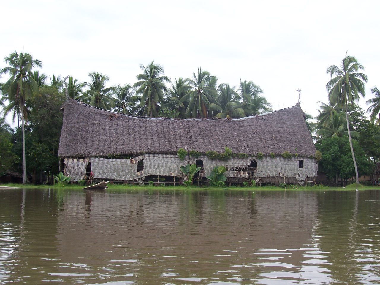 an old house sits next to the waters in a village