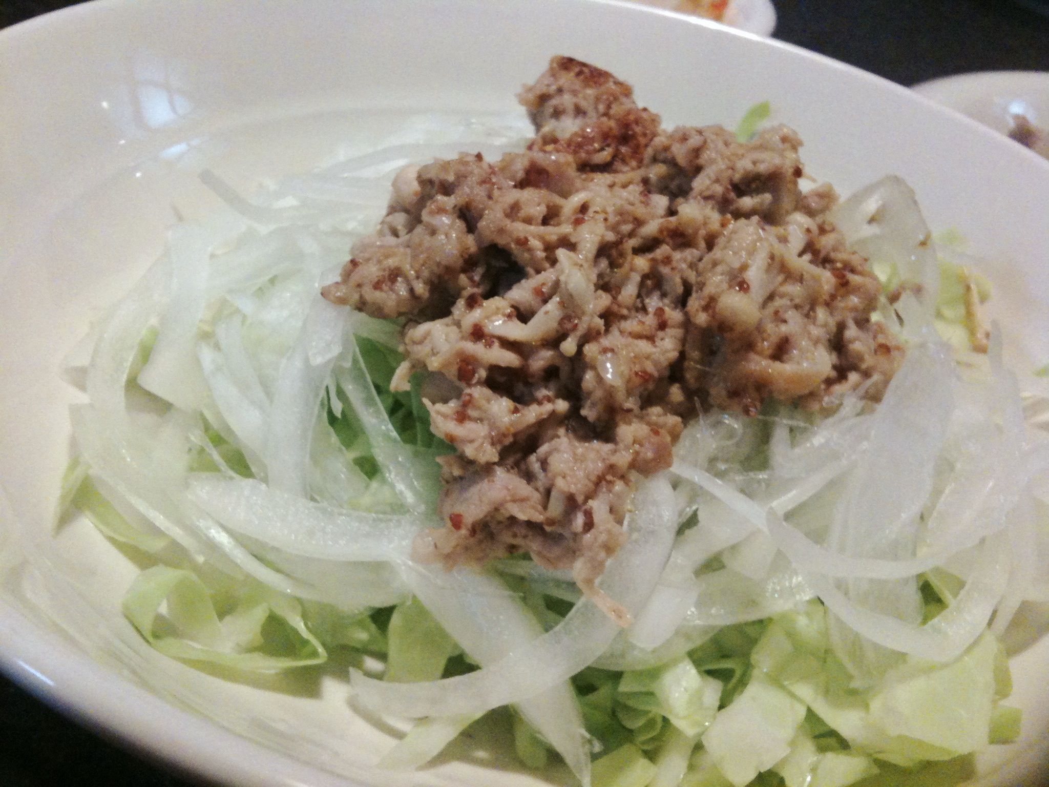 meat and some lettuce in a white bowl