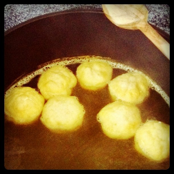 balls of yellow cake batter in a saucepan, with a spoon nearby