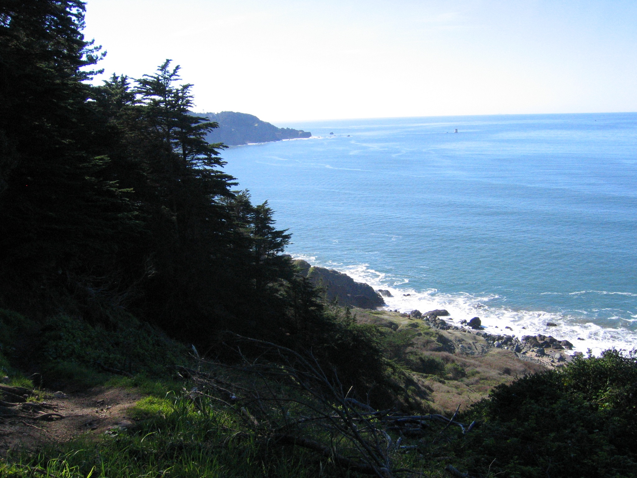 the view down at a beach from the mountains on a sunny day