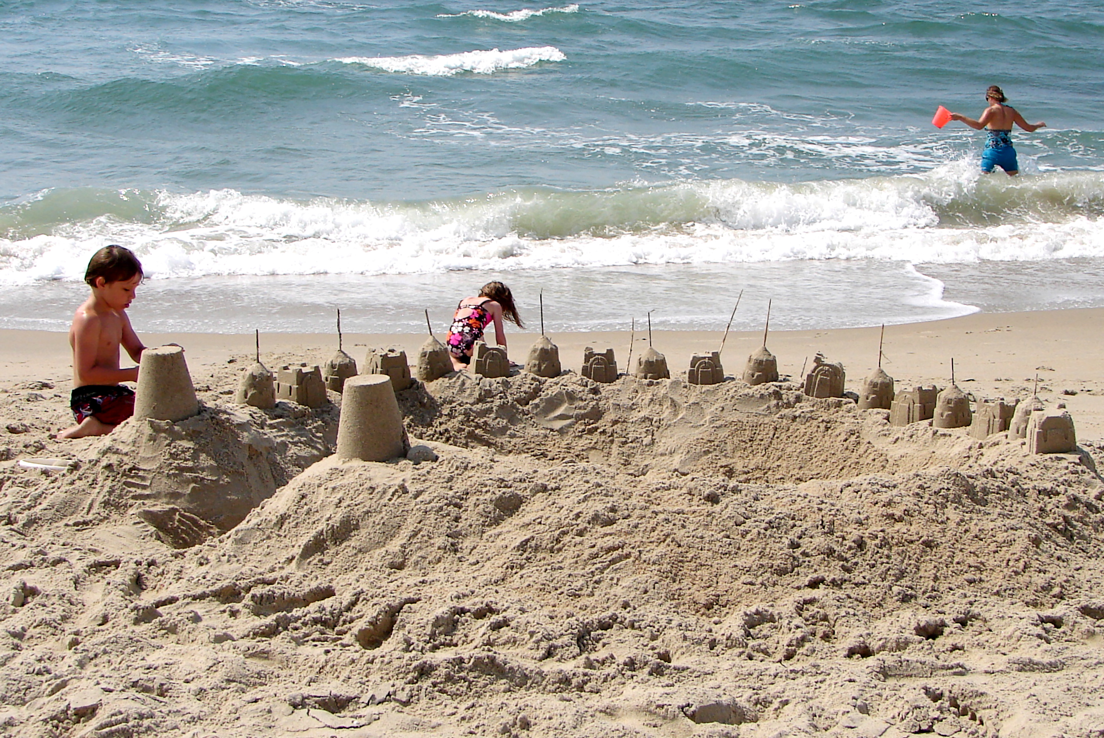 children playing at the beach with sand castle