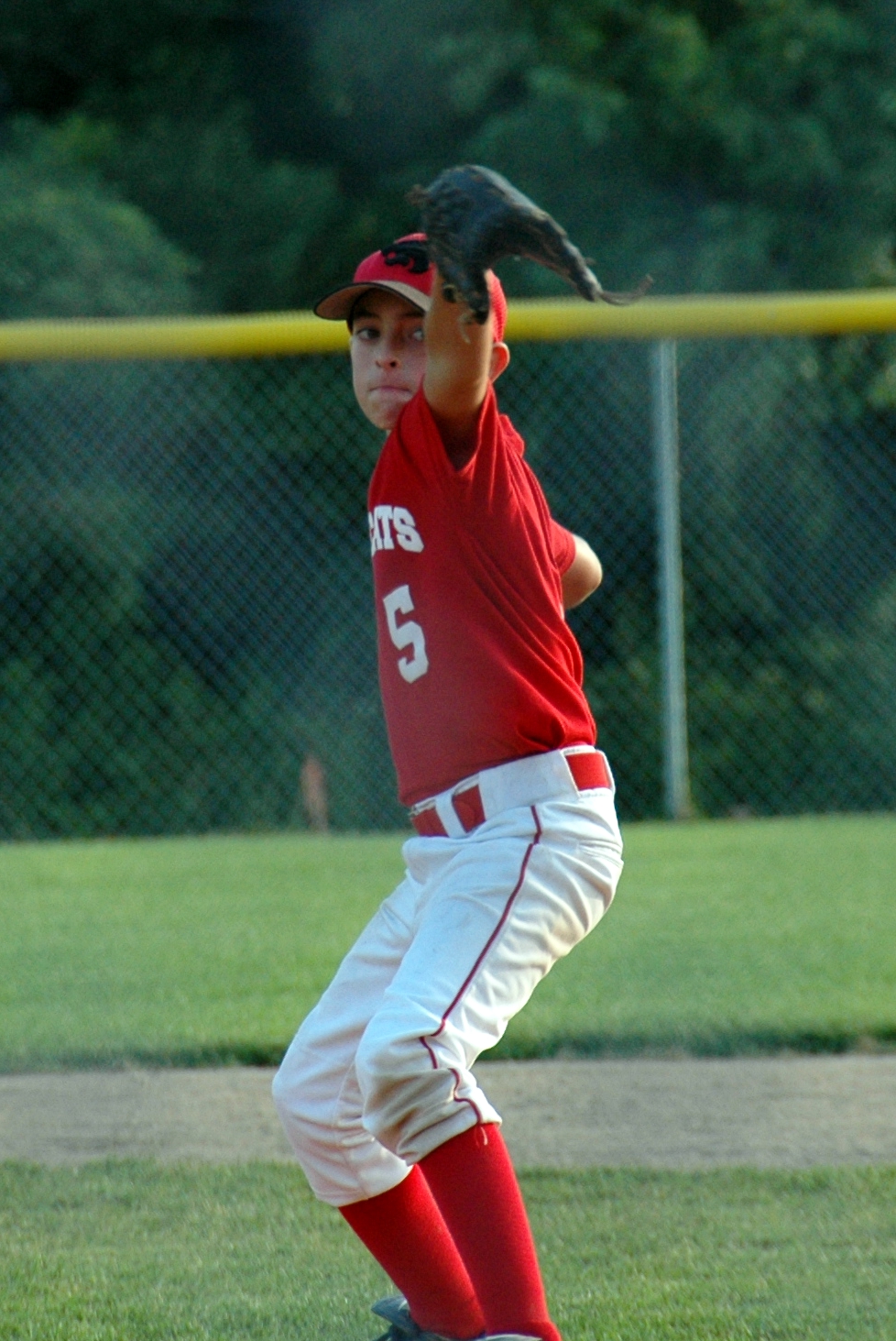 a  in a baseball uniform is catching a ball