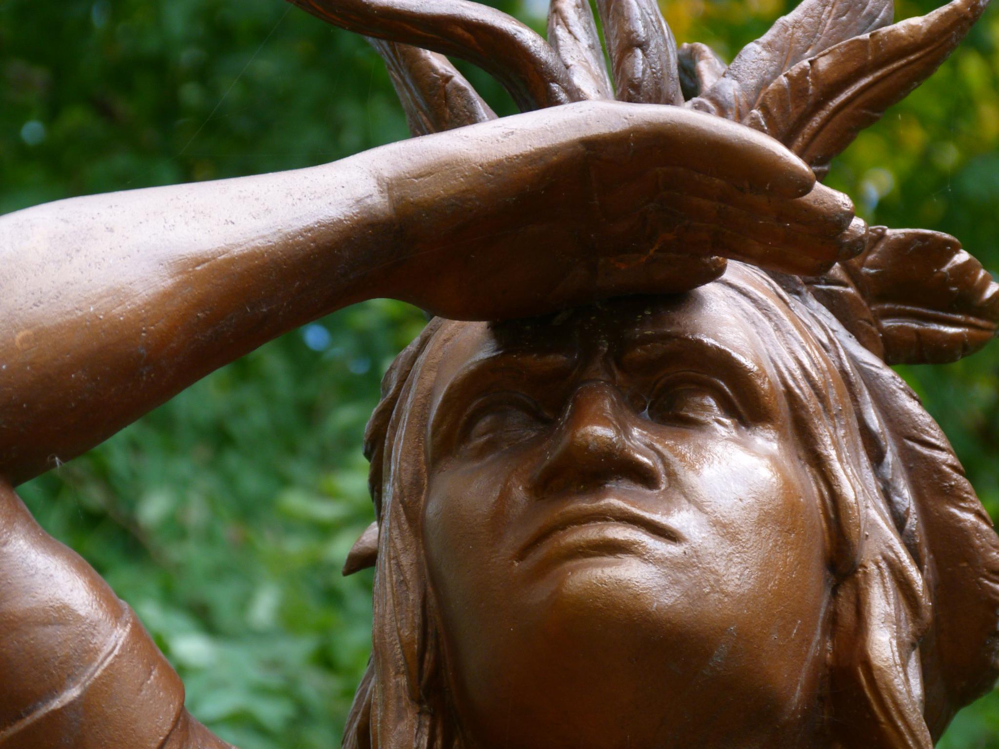 closeup of a statue with leaves on it's head