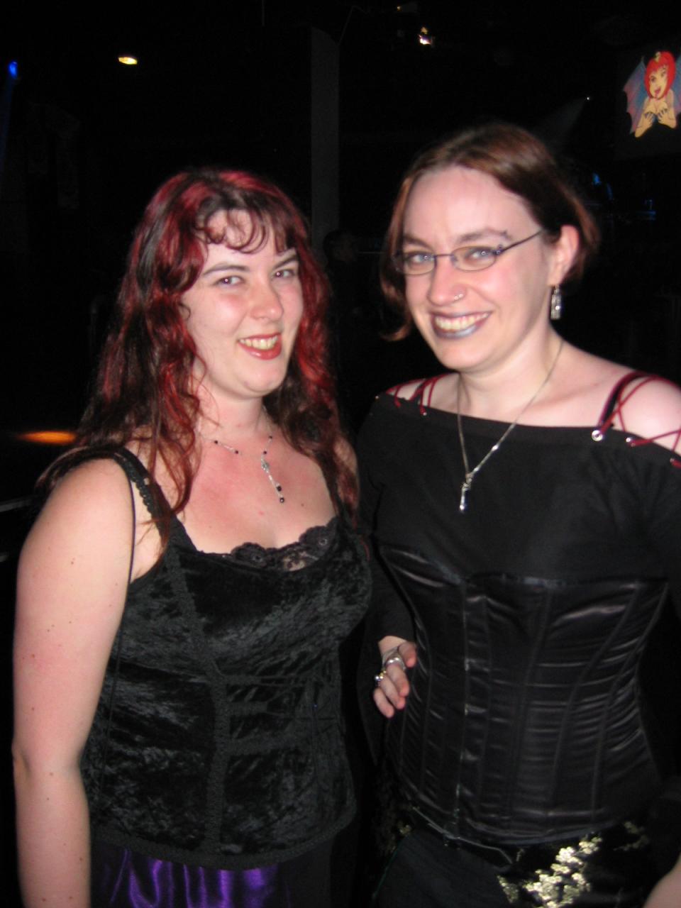 two women pose for a po together in formal dress