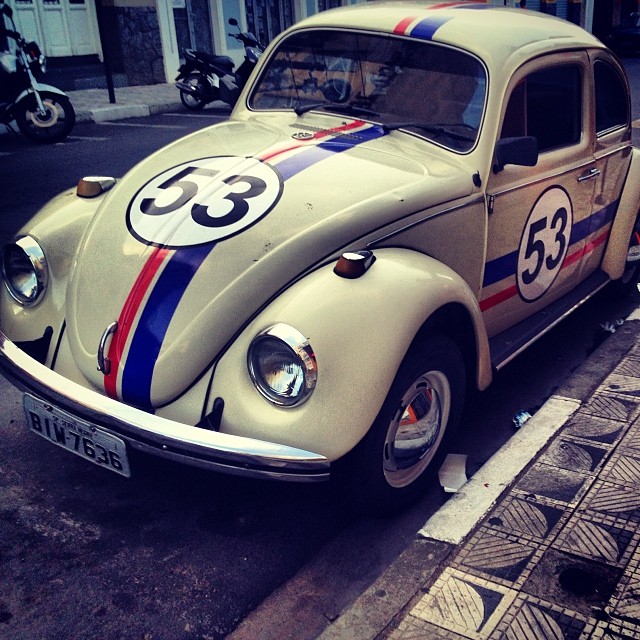 an old beetle that is sitting on the side of a street
