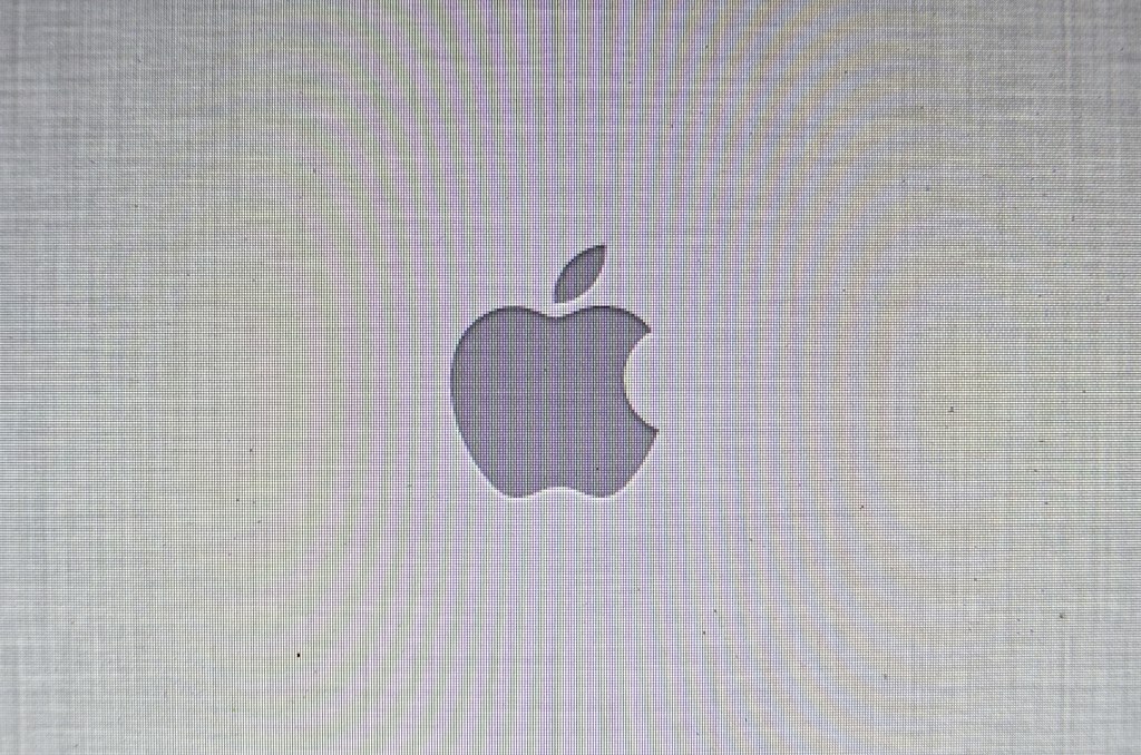 a computer screen showing the apple logo with many small white dots on it