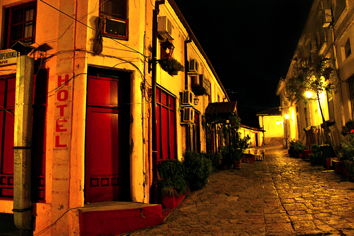 a building at night in an old street with a red door
