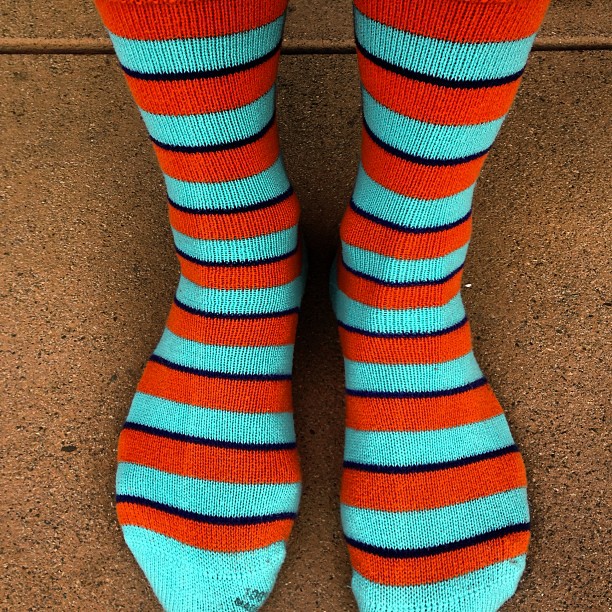 a person's legs wearing blue and orange striped socks