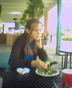 a woman sits at a table with food on it