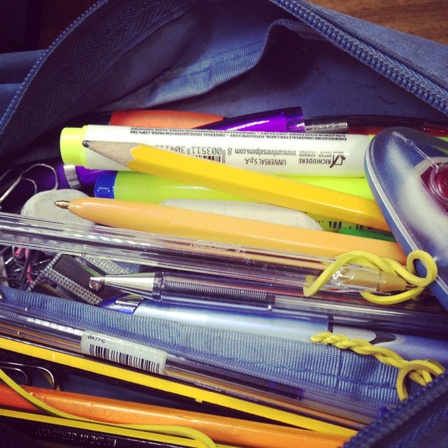 there is a school bag filled with pens and school supplies